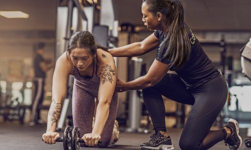 A personal trainer records herself coaching her client, a personal training marketing tip that helps populate social media marketing.