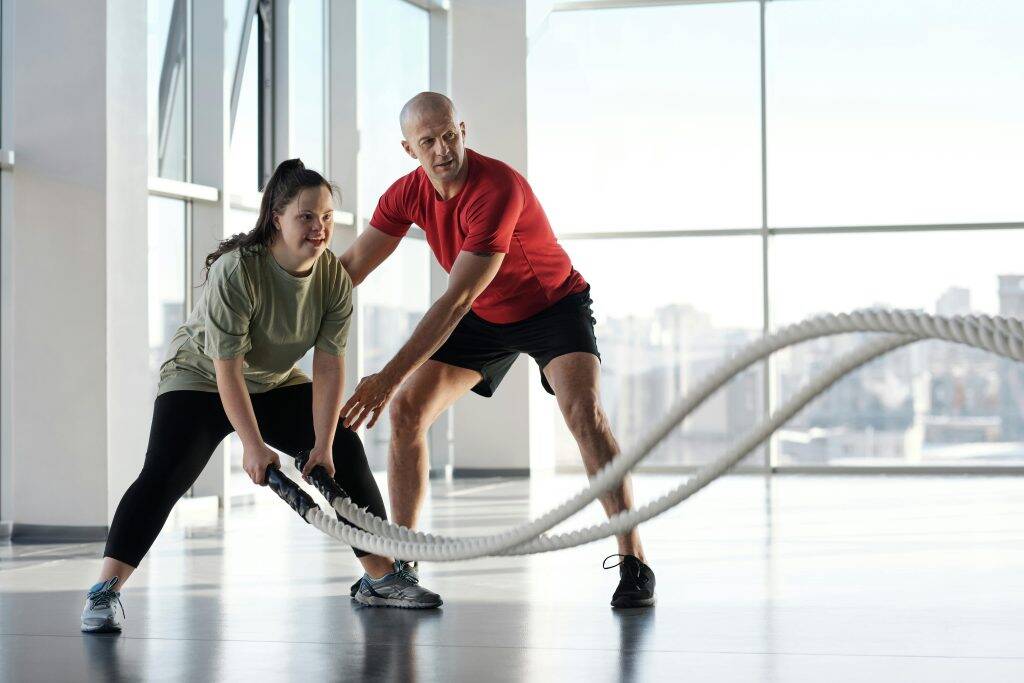 Individuals working out in a fitness environment, representing the role of personal trainers in guiding exercise routines and ensuring safety.