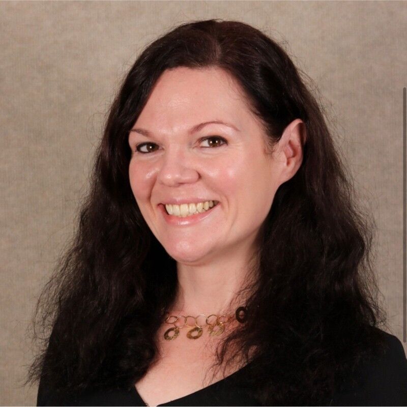 Woman with dark hair and black shirt smiling